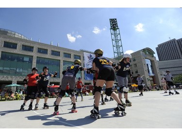 The Slaughter Daughters, in red, take on their league mates Riot Squad during the Rideau Valley Roller Girls' Roller Derby Expo at the Rink of Dreams at Ottawa City Hall's Marion Dewar Plaza in Ottawa on Saturday, July 12, 2014.