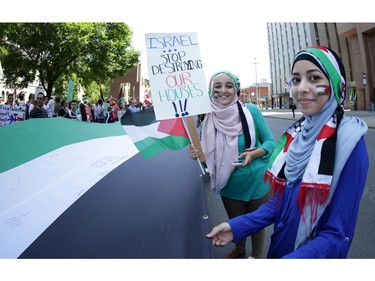 These two young girls were among hundreds of people who rallied in support of Palestine at the Human Rights Memorial in Ottawa, Saturday, July 12, 2014. Many brought banners and flags, and chanted, and later, they marched toward another rally in front of the US embassy on Sussex Dr.