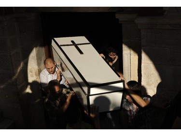 Palestinians carry the coffin of Jalila Ayad, a Christian woman whose body was found under the rubble of her home after an Israeli airstike in Gaza City during her funeral on July 27, 2014. The Islamist Hamas movement continued firing rockets at Israel, despite claims it had accepted a UN request for a 24-hour extension of a humanitarian truce in war-torn Gaza.