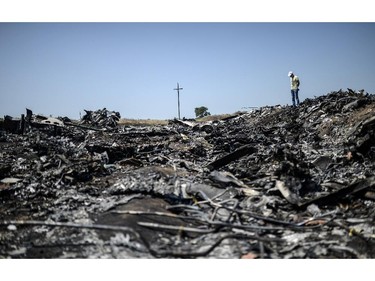 TOPSHOTS  A man stands at the crash site of the Malaysia Airlines Flight MH17 on July 26, 2014, near the village of Hrabove (Grabove), in the Donetsk region. Ukraine sought on July 25 to avoid a political crisis after the shock resignation of its prime minister, as fighting between the army and rebels close to the Malaysian airliner crash site claimed over a dozen more lives. Dutch and Australian forces were being readied on July 26 for possible deployment to secure the rebel-held crash site of the Malaysia Airlines flight MH17 in east Ukraine where many victims' remains still lie nine days after the disaster claimed 298 lives.