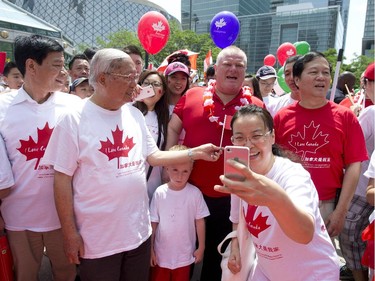 Toronto Mayor Rob Ford sings "Oh Canada" while people take photos of him shortly before marching in the National Congress of Chinese Canadians' Canada Day parade in Toronto, Ontario on Tuesday, July 1, 2014.  The parade started at Metro Hall, marched through Chinatown and ended at the Rogers Centre.