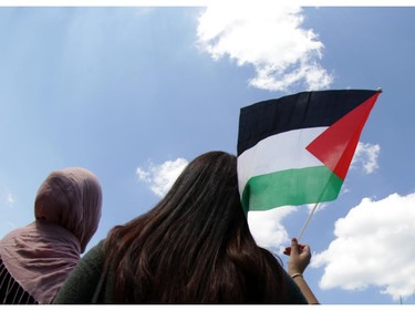 Two woman among several hundreds at a rally in support of Palestine at the Human Rights Memorial in Ottawa, Saturday, July 12, 2014. Many brought banners and flags, and chanted, and later, they marched toward another rally in front of the US embassy on Sussex Dr.