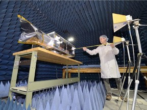 UNDATED -- A technician putting some of the finishing touches on NEOSSat at the David Florida Laboratory located in Ottawa before the satellite was sent to India for launch. NEOSSat is a dual-mission microsatellite designed to detect potentially hazardous Earth-orbit-crossing asteroids and track space debris. (Credit: Janice Lang, DRDC)    For Margaret Munro (Postmedia News) SPACE-PATROL ORG XMIT: POS1302212125129392