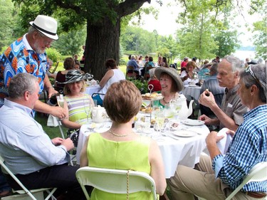 Volunteer Don West serves some bubbly to guests at the High Tea for Ryan's Well Foundation charity event, held Sunday, July 20, 2014, at a private home in Plaisance, Quebec.