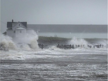 Waves crash against rock embankments that protect the Escuminac road against erosion during Tropical storm Arthur in Escuminac, N.B. on Saturday, July 5, 2014.