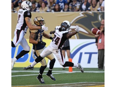 Winnipeg Blue Bombers Nick Moore is surrounded by Ottawa Redblacks Eric Frazer, left, and Jerell Gavins in the endzone during first half  CFL action at Investors Group Field in Winnipeg Thursday night- See Paul Wiecek story- July 03, 2014   (JOE BRYKSA / WINNIPEG FREE PRESS)