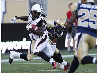 Ottawa Redblacks' Chevon Walker (29) breaks the tackle by Winnipeg Blue Bombers' Maurice Leggett (31) and runs the ball in for the touchdown during the first half of CFL action in Winnipeg on Thursday, July 3, 2014.