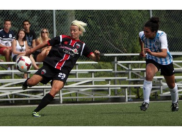 Women's Ottawa Fury FC's Kristy Moore eyes a ball as she kicks it upfield against a Kitchener-Waterloo United FC defender during play action at Algonquin College Field on Saturday, July 19, 2014. (Cole Burston/Ottawa Citizen)