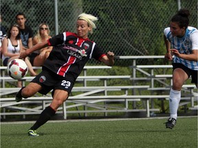 Women's Ottawa Fury FC's Kristy Moore eyes a ball as she kicks it upfield against a Kitchener-Waterloo United FC defender during play action at Algonquin College Field on Saturday, July 19, 2014. (Cole Burston/Ottawa Citizen)