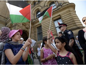 Young people wave the Palestinian flag in front of the Langevin Block in support of Palestinians in Gaza on Tuesday.