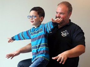 Dr. Tony Sandorfi, from The Happy Spine Wise Body Studio in Westboro, tests six-year-old Mason Seguin's posture.