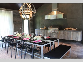 Combining the rustic look of barn board and the contemporary feel of stainless steel creates a warm juxtaposition. Along with the walls, custom cabinetry in this outdoor kitchen by Jennifer McGahan add a distinct look.