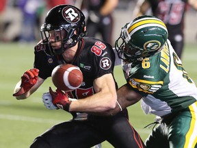 Ottawa's Matt Carter gets the ball knocked out from his grip by Edmonton's Alonzo Lawrence near the 20-yard line with less than three minutes left in the game, as the Ottawa Redblacks hosted the Edmonton Eskimos at TD Place in Ottawa, August 15, 2014.