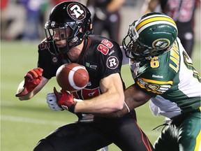 Ottawa's Matt Carter gets the ball knocked out from his grip by Edmonton's Alonzo Lawrence during the Ottawa Redblacks matchup against the Edmonton Eskimos at TD Place in Ottawa on Aug. 15. It was the first fumble the Redblacks lost.