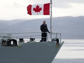 Canadian Prime Minister Stephen Harper stands on the bow of the HMCS Kingston as it sails in the Navy Board Inlet Sunday August 24, 2014. THE CANADIAN PRESS/Adrian Wyld