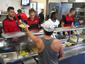 Fury FC team mates Devala Gorrick; Marcel DeBellis with Redblacks Chevon Walker and Fury FC Omar Jarun on the service table. Redblacks and Fury FC team members where at the Shepherds of Good Hope to help serve some lunch.