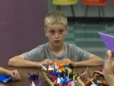 Eight-year-old Finn is one of the Spy Camp Kids at the Diefenbunker in Carp are folding paper cranes in an Origami class to send to Japan. They hope is to make between 600 and 1,000 cranes.