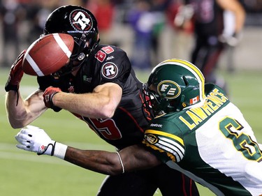 Ottawa's Matt Carter gets the ball knocked out from his grip by Edmonton's Alonzo Lawrence near the 20-yard line with less than three minutes left in the game as the Redblacks hosted the Edmonton Eskimos at TD Place in Ottawa, August 15, 2014.