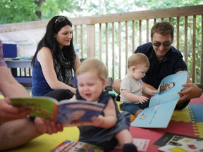8-month-old Alexander Jaltema reads during Story Time at Rideau Hall on Saturday, August 23, 2014 with the help of a Frontier College volunteer and parents Steve Jaltema and Ashley Crossley.