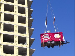 A Grill Master Express food trailer is lifted to the top of a 21-storey condo tower at Lansdowne Park Tuesday, August 19, 2014.