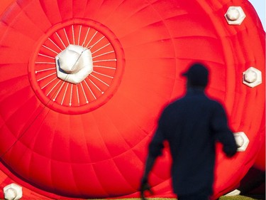 A man is silhouetted in an inflating balloon before a morning flight.