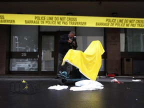 A police investigator looks around the scene of an early morning stabbing at Embassy Hotel & Suites near Ottawa City Hall on Wednesday, July 30, 2014. (Cole Burston/Ottawa Citizen)