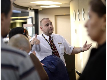 A Via Rail staff member speaks to customers at the Ottawa Train Station as Via Rail service was disrupted following a derailment near Ganaoque on Friday, August 1, 2014.