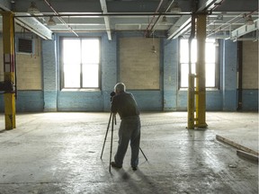 A Workers' History Museum volunteer photographs the interior of a Domtar building on Chaudiere Island.