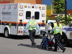 A young boy on a stretcher is wheeled toward an ambulance by paramedics from St. Cecile Catholic School in Barrhaven.