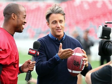 Ben Mulroney, from E talk, interviews QB Henry Burris and gets a few tips on how to throw a ball.  Ottawa Redblacks run through a light practice Thursday, August 14, 2014 at TD Place stadium before Friday night's home game against the Edmonton Eskimos.