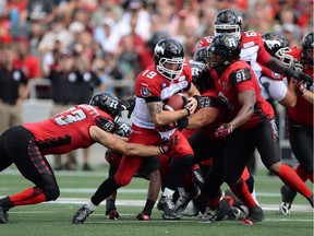 Calgary Stampeders' quarterback Bo Levi Mitchell runs the ball as Ottawa Redblacks' Justin Capicciotti, left, attempts a tackle during first half CFL action in Ottawa on Sunday, Aug. 24, 2014.