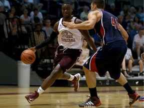 Caleb Agada #6 of the Ottawa Gee-Gees dribbles the ball against Jake Wiegand #40 of the University of Illinois at Chicago Flames during a CanAm Shoot game at Montpetit Hall in Ottawa on August 13, 2014.