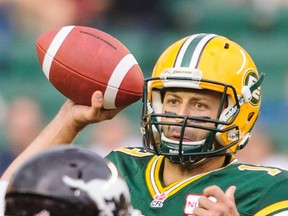 EDMONTON, AB - JULY 24: Mike Reilly #13 of the Edmonton Eskimos looks up field for a teammate to pass to during a CFL game against the Calgary Stampeders at Commonwealth Stadium on July 24, 2014 in Edmonton, Alberta, Canada.