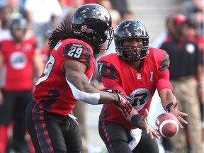 Henry Burris of the Ottawa Redblacks hands the ball off to teammate Chevon Walker during a CFL game against the Calgary Stampeders at TD Place stadium on Aug. 24, 2014 in Ottawa.