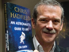 Retired Canadian astronaut Chris Hadfield holds a copy of his new book "An Astronaut's Guide to Life on Earth" while on a media tour in Montreal on November 27, 2013. Former astronaut Chris Hadfield's next adventure may involve prime-time TV. His book, "An Astronaut's Guide To Life On Earth," is the inspiration for a TV pilot being commissioned by ABC.