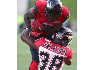 Dobson Collins #80 of the Ottawa Redblacks is tackled by Buddy Jackson #38 of the Calgary Stampeders during a CFL match at TD Place in Ottawa on August 24, 2014.