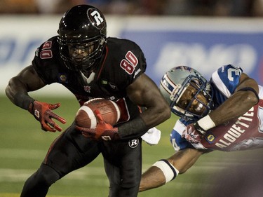 Ottawa Redblacks wide receiver Dobson Collins is tackled by Montreal Alouettes linebacker Kyries Hebert during second quarter CFL football action Friday, August 29, 2014 in Montreal.