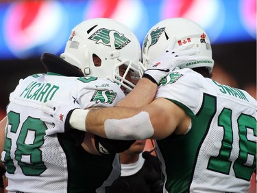 Dominic Picard (68) and Brett Swain (16) celebrate a Saskatchewan Roughriders touchdown against the Ottawa Redblacks during the first half of CFL game action at TD Place in Ottawa on Saturday, Aug. 2, 2014.