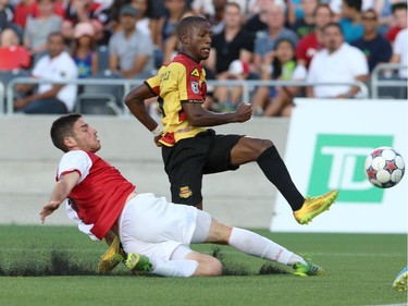 Drew Beckie #4 of the Ottawa Fury slides into Fafà Picault #11 of the Fort Lauderdale Strikers as Picault scores a goal during an NASL match at TD Place in Ottawa on August 9, 2014.