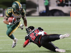 Edmonton's Kendial Lawrence deftly jumps over Ottawa's Seth Williams' tackle during the Ottawa Redblacks Friday night matchup against the Edmonton Eskimos at TD Place in Ottawa.