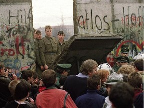 West Berliners crowd in front of the Berlin Wall on Nov. 11, 1989 as they watch East German border guards demolishing a section of the wall in order to open a new crossing point between East and West Berlin near Potsdamer Square.