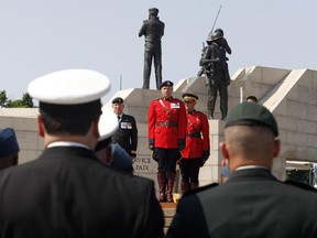 Former and current Canadian Peacekeepers stand at the National Peacekeepers Day Ceremony at the Peacekeeping Monument in Ottawa on Sunday, August 10, 2014.