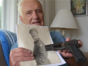 Jacques Rochon, 93, of Ottawa holds the pistol his brother was carrying when he was killed in action in Germany in 1945. Maj. Robert Rochon is one of 1,355 Canadian soldiers buried at the Holten Canadian War Cemetery in the Netherlands.