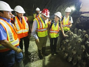 From left center, MP Royal Gallipeau, Ontario Premier Kathleen Wynne and Ottawa Mayor Jim Watson examine one of the rock cutting machines during a tour of the Confederation Line Light Rail Train tunnel construction Monday, August 11, 2014.