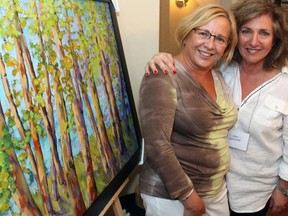 From left, Karin Bercovitch bought this landscape piece on Wednesday, August 13, 2014, at an Epic Walk for Cancer fundraiser that Sara Lipnowski, right, painted in memory of her dear friend, Gary Steinberg, who died of cancer last November.