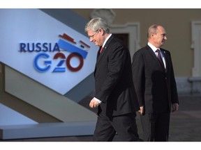 Canadian Prime Minister Stephen Harper walks past Russian President Vladimir Putin at the G20 Summit Thursday Sept.5, 2013 in St.Petersburg, Russia. The federal government says it will impose new sanctions against Russia in coming days over Moscow's support of rebel groups in Ukraine.