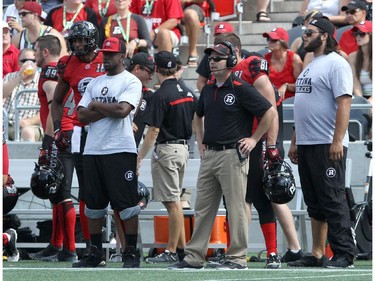 Head Coach Rick Campbell (2ndFR) of the Ottawa Redblacks looks on from the sidelines during a CFL match against the Calgary Stampeders at TD Place in Ottawa on August 24, 2014.
