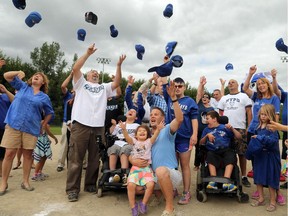 Ian Dufton. centre, and his five-year-old daughter Ashlyn, who suffers from a chromosome-related disability, throw their hats in the air in celebration with the Desrochers family, left, and the Schleyer family, right. The Miracle League of Ottawa got a gift this week from the Toronto Blue Jays - $210,000 to help build Ottawa's first baseball field for children with special needs.