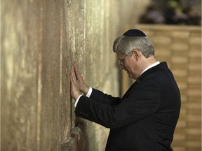 Prime Minister Stephen Harper touches the Western Wall, Judaism's holiest site in Jerusalem's old city on January 21, 2014.