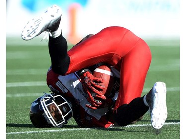 Calgary Stampeders' Joe West lands on his head after making a catch against the Ottawa Redblacks during CFL action in Ottawa on Sunday, Aug. 24, 2014.